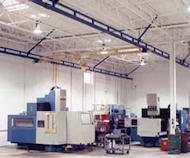 Ceiling supported bridge crane set up in a warehouse for transporting heavy materials.